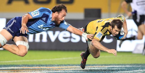 Chris Lowrey fails to stop Conrad Smith as he scores the winning try for the Hurricanes against the Blues. Photo / Greg Bowker.