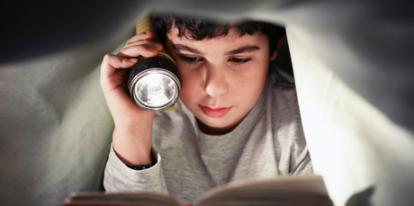 Reading under the cover of darkness may not protect children from bleak tales of lost childhoods found through the portal of their story books. Photo / Thinkstock