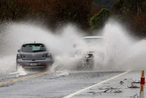 Cars throw up curtains of water on flooded State Highway 1 just north of Turangi. Heavy rain fell over the North Island yesterday as the front moved across the country. Photo / Alan Gibson