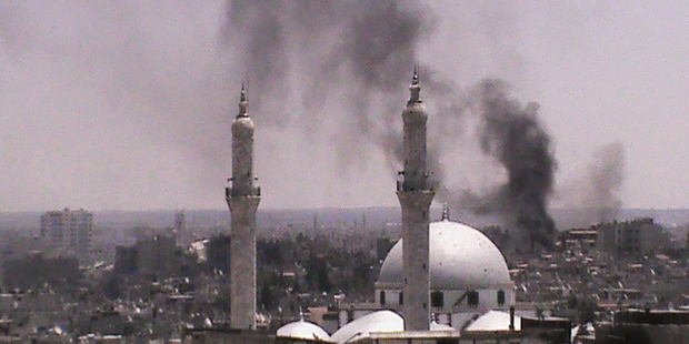 In this citizen journalism image provided by Shaam News Network SNN, black smoke rises from buildings near a mosque from purported forces shelling in Homs, Syria. Photo / AP