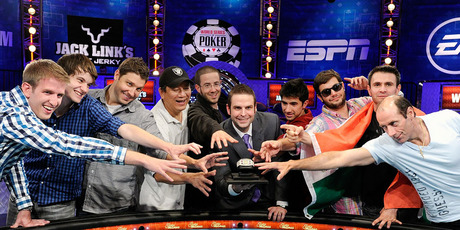 Tournament director Jack Effel, center holding a trophy, poses with the final nine players after the conclusion of the Main Event at the 43rd annual World Series of Poker. Photo / AP.
