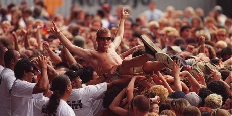Concert security gives one of the crowd a hand across the barrier from the mosh pit during the 1999 Big Day Out. File photo / Brett Phibbs