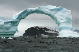 A dramatic arch of ice at Cuverville Island in Antarctica dwarfs the Aleksey Maryshev. Photo / Jim Eagles