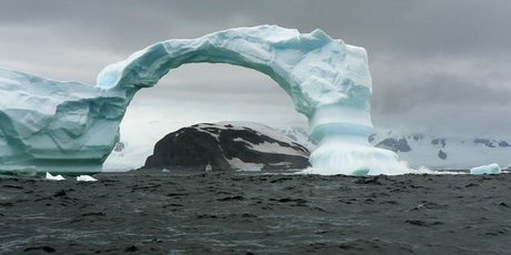 A dramatic arch of ice at Cuverville Island in Antarctica dwarfs the Aleksey Maryshev. Photo / Jim Eagles