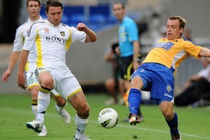 Tim Brown of the Phoenix contests for the ball with Peter Jungschlager of Gold Coast United. Photo / Getty Images