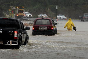 A stranded motorist near Waihi Beach makes his way through the floodwaters on foot after several vehicles became stuck in floods in the Bay of Plenty this week. Photo / A;an Gibson