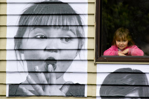 Glen Innes 3-year-old Koalani Patuwai watches her image being put up as part of an international community art project. Picture / Richard Robinson