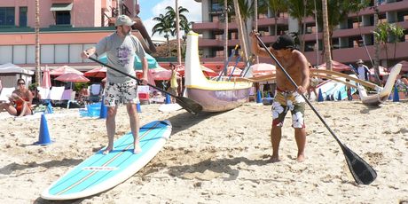 Jim Eagles (left) is taught paddle skills on Waikiki Beach. Photo / Jim Eagles