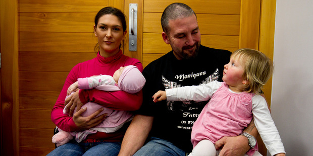 Sam Barker, with Kashine, and Scott Richards are relieved to have Alyssa home. Photo / NZ Herald