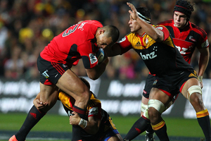 Robbie Fruean of the Crusaders looks to beat the tackle of Tanerau Latimer. Photo / Getty Images