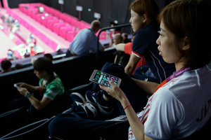 Satoko Suetsuna watches badminton matches with Twitter on her phone at hand. Photo / AP