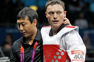 New Zealand's Logan Campbell with his coach, Jin Keun Oh, after losing his preliminary round Taekwondo fight against Hryhorii Husarov of the Ukraine. Photo / Mark Mitchell NZ Herald