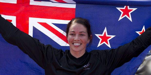 Sarah Walker holds the New Zealand flag after winning silver in the women's BMX race. Photo / Brett Phibbs