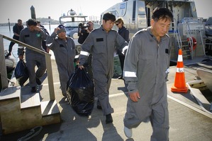 The rescued men come ashore at Mechanics Bay. Photo / Jason Dorday