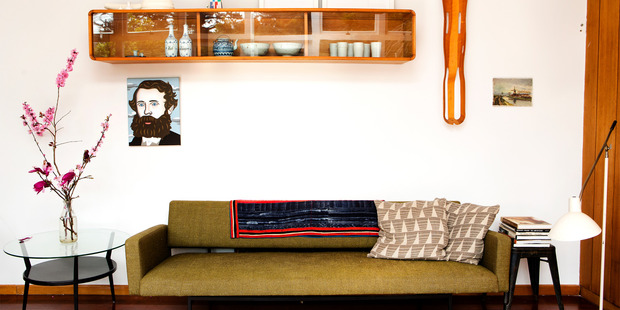 Heath Lowe's European green sofa bed with wall unit in the living room of his Birkenhead home. Photo / Babiche Martens