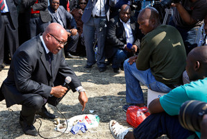 South Africa's President Jacob Zuma, left, interacts with striking mine workers at the Lonmin mine near Rustenburg. Photo / AP