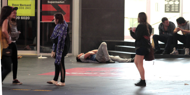 A youth collapses on Queen St in the early hours of the morning. Photo / Geoff Dale