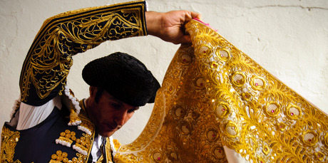 A Spanish bullfighter adjusts his 'capote' as he prepares for action. Photo / AP