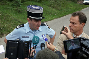 Eric Maillaud (right) and a police colonel answer questions near the murder scene yesterday. Photo / Alexis Moro