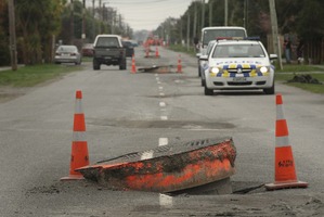 Cars drive around manhole covers in Brooklands moved by the earthquake in September 2010. Photo / Alan Gibson
