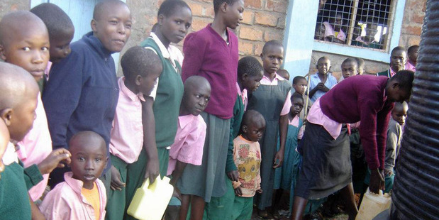 Students at Ikoba Primary School in Kenya line up at a water tank donated directly to them by School Aid. Photo / Supplied