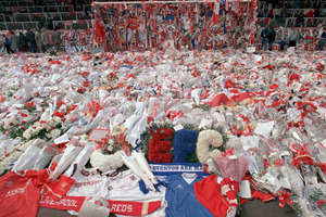 Liverpool soccer fans arrive at Anfield Stadium to pay their respects as flower tributes cover the 'Kop' end of the field, in Liverpool, on April 17, 1989. Photo / AP