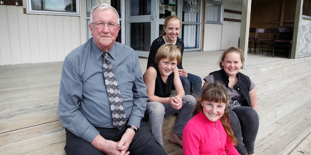Murray Thompson, 79, with Pukeatua School pupils (from left) Mika Harris, Nikita Beck, Emma Anderson and Julia Mickell on the steps of the Matapihi Education Centre where he's a volunteer. Photo / Christine Cornege