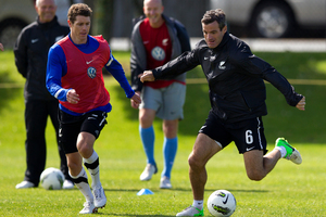 All Whites captain Ryan Nelsen takes on Tony Lochhead, left, during training at Albany yesterday. Photo / Brett Phibbs