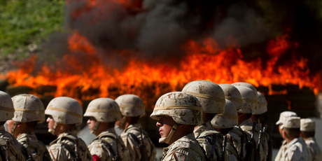 Soldiers stand in formation as a pile of marijuana burns in Tijuana. The Government's commitment to the war on drugs is undermined by corruption. Photo / AP