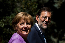 Spain's Prime Minister Mariano Rajoy walks with German Chancellor Angela Merkel in Madrid. Photo / AP 