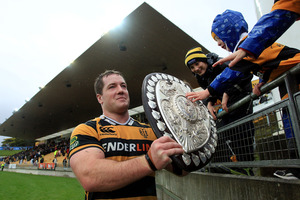 Michael Bent of Taranaki shows the Log o' Wood to some young fans. Photo / Getty Images