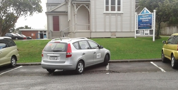 A reader writes: 'When picking up our children from kindy we found this Auckland council car using not one, not two but THREE parking spaces while he went along the road handing out parking tickets. His excuse? I was only gone a minute.' Photo / Supplied