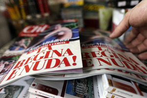 A newstands owner adjusts copies of the Italian magazine Chi reading in Italian 'The queen is naked'. Photo / AP