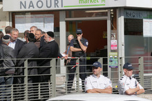 Members of the Jewish community talk in front of the kosher grocery store after the attack. Photo / AP