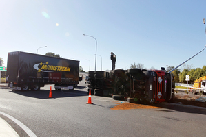 An injured driver had to be cut free after his truck and trailer overturned in Taupiri at a roundabout designed to improve safety. Photo / Christine Cornege