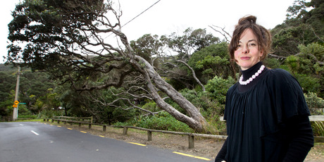 Megan Vertelle in front of the limb of the Piha pohutukawa tree she wants to save. Photo / Steven McNicholl
