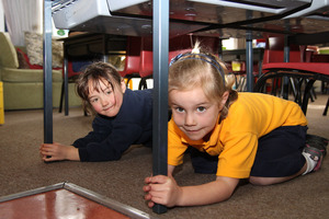At Spreydon School's new entrant class, Mihana Hof (5) and Chloe Palmer (6) practice the Drop, Cover and Hold drill. Photo / NZ Herald