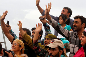 Kashmiri Muslims wave as a bus carrying Hajj pilgrims, unseen, leaves for the annual Hajj pilgrimage. Photo / AP