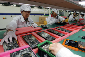 Staff members work on the production line at the Foxconn complex in the southern Chinese city of Shenzhen. Photo / AP