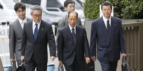Olympus' former President Tsuyoshi Kikukawa (front centre) arrives with his lawyers at Tokyo District Court. Photo / AP