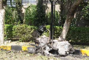 A damaged car is seen near Syria's army command headquarters in Damascus, Syria. Photo / AP