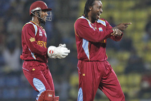 West Indies' wicketkeeper Denesh Ramdin, left, laughs as teammate Chris Gayle dances after he took the wicket of England's batsman Jonny Bairstow. Photo / AP