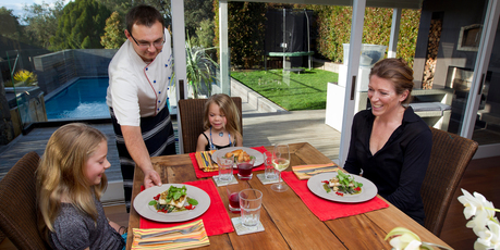 Personal chef Andrei Kainer serves dinner to Hannah Bell (left), 8, Sydney Bell, 5, and Robin Bell. Picture / Sarah Ivey