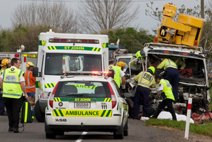 Emergency services help a man trapped in a truck after a head-on near Paengaroa. The car driver died. Photo / Joel Ford
