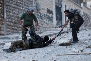 Free Syrian Army soldiers help a severely wounded colleague after being shot by a Syrian srmy sniper in Izaa district, earlier this month. Photo / AP