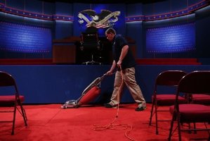 Shaun Spink vacuums during preparation for the Presidential Debate at the University of Denver this afternoon. Photo / AFP