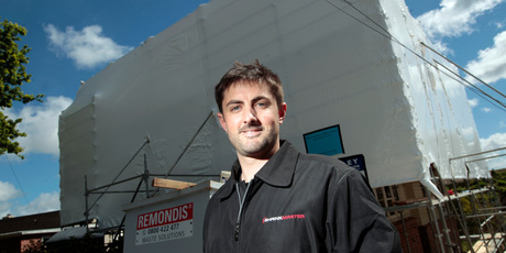 Chris Ramsey at one of the buildings his company has shrinkwrapped. Photo / Michael Craig