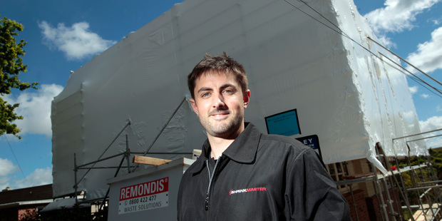 Chris Ramsey at one of the buildings his company has shrinkwrapped. Photo / Michael Craig