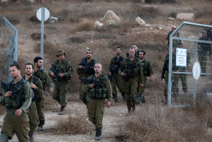 Israeli soldiers search for the remains of the drone (below) shot down by the air force in Israeli airspace. Photo / AP