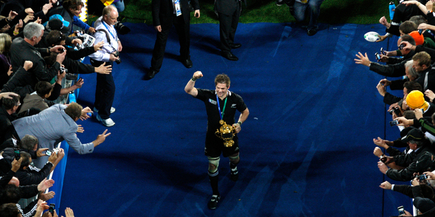 New Zealand All Blacks captain Richie McCaw leaves the field with the Webb Ellis Cup after winning the final of the RWC 2011 against France at Eden Park Auckland. Photo / Richard Robinson